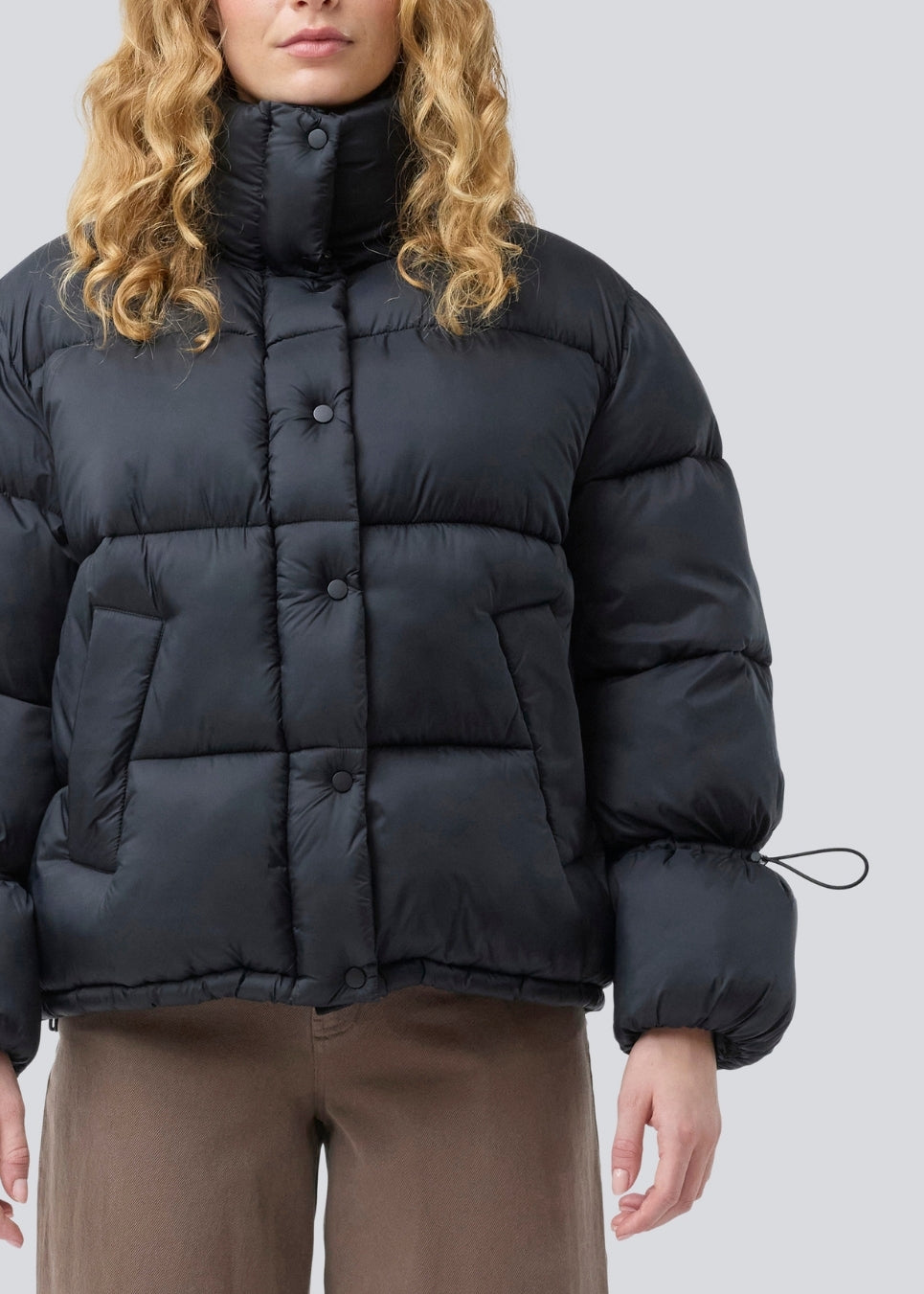 Sort dunjakke med høj hals i 100% genanvendt polyester. Odinmd jacket har en lynlåslukning og en justerbar elastik i ærmet. Modellen er 175 cm og har en str. s/36 på.
