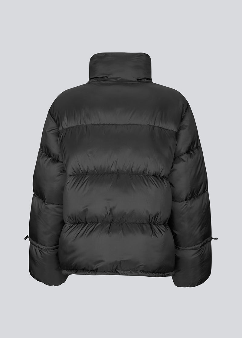 Sort dunjakke med høj hals i 100% genanvendt polyester. Odinmd jacket har en lynlåslukning og en justerbar elastik i ærmet. Modellen er 175 cm og har en str. s/36 på.
