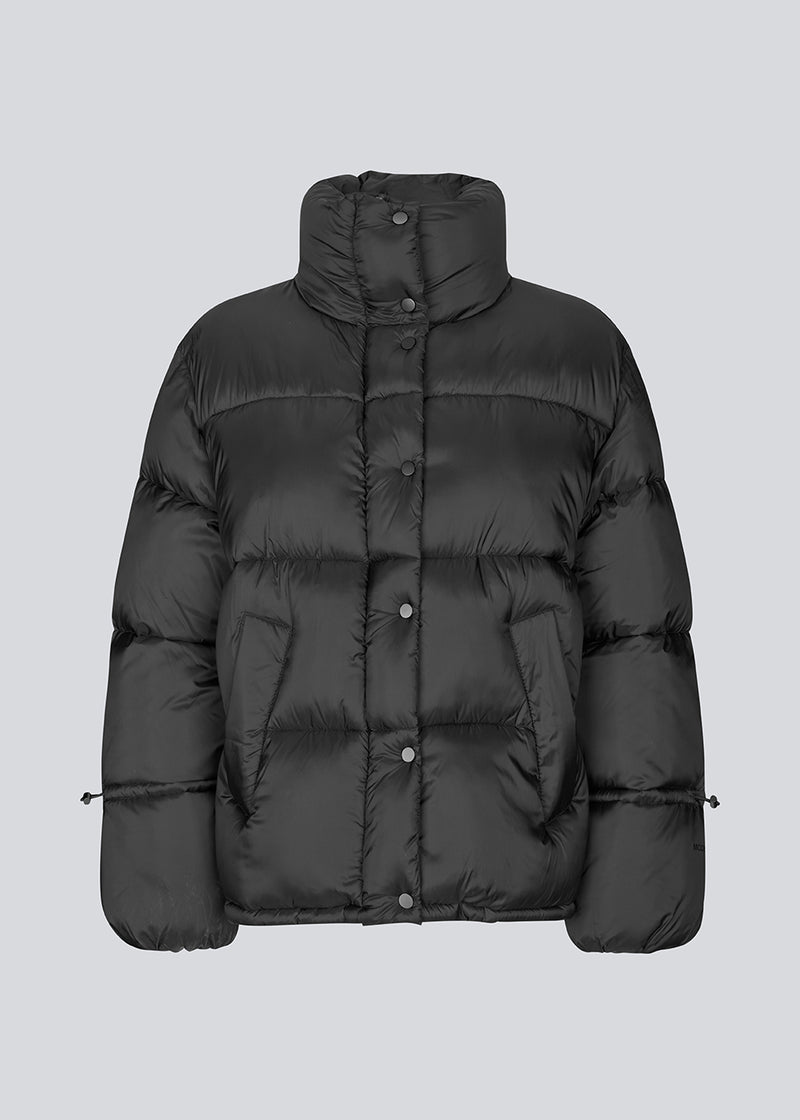 Sort dunjakke med høj hals i 100% genanvendt polyester. Odinmd jacket har en lynlåslukning og en justerbar elastik i ærmet. Modellen er 175 cm og har en str. s/36 på.
