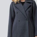 Klassisk, dobbeltradet uldfrakke med krave og revers. Olinamd coat er let figursyet, har foer og en slids bagpå. Modellen er 175 cm og har en str. s/36 på.