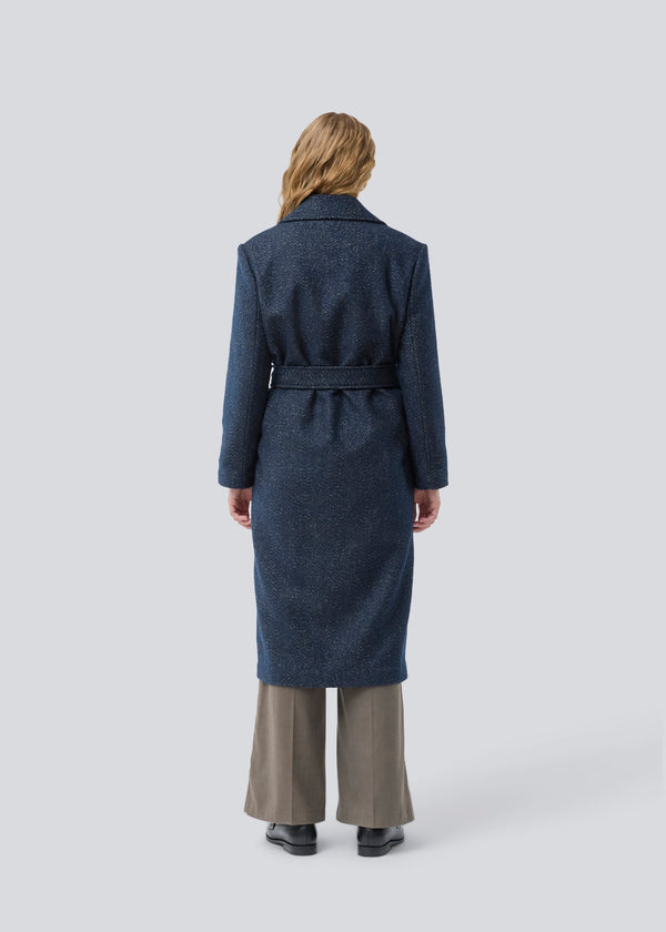 Klassisk, dobbeltradet uldfrakke i blå med krave med skjult knappelukning og bindebånd. Otillamd coat har en afslappet pasform, foer og en slids bagpå. Modellen er 175 cm og har en str. s/36 på.
