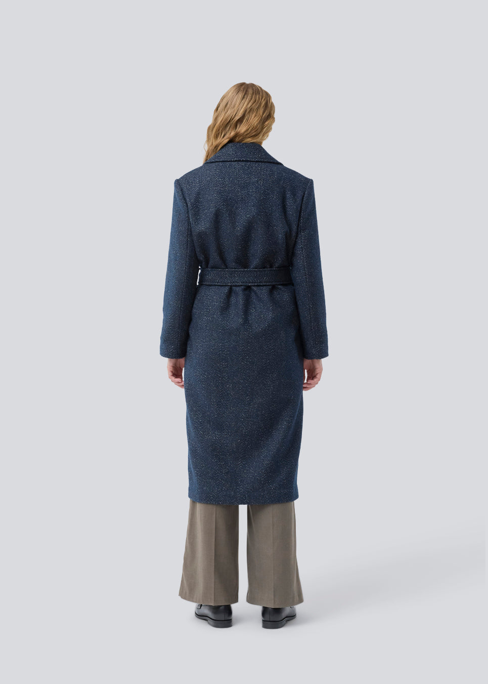 Klassisk, dobbeltradet uldfrakke i blå med krave med skjult knappelukning og bindebånd. Otillamd coat har en afslappet pasform, foer og en slids bagpå. Modellen er 175 cm og har en str. s/36 på.
