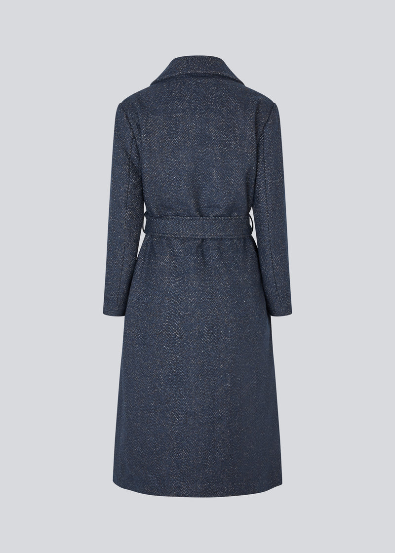Klassisk, dobbeltradet uldfrakke i blå med krave med skjult knappelukning og bindebånd. Otillamd coat har en afslappet pasform, foer og en slids bagpå. Modellen er 175 cm og har en str. s/36 på.