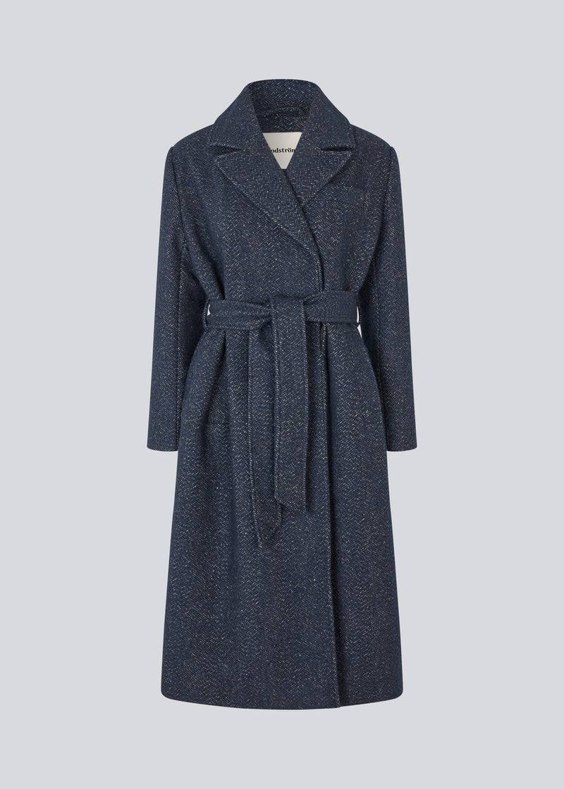 Klassisk, dobbeltradet uldfrakke i blå med krave med skjult knappelukning og bindebånd. Otillamd coat har en afslappet pasform, foer og en slids bagpå. Modellen er 175 cm og har en str. s/36 på.