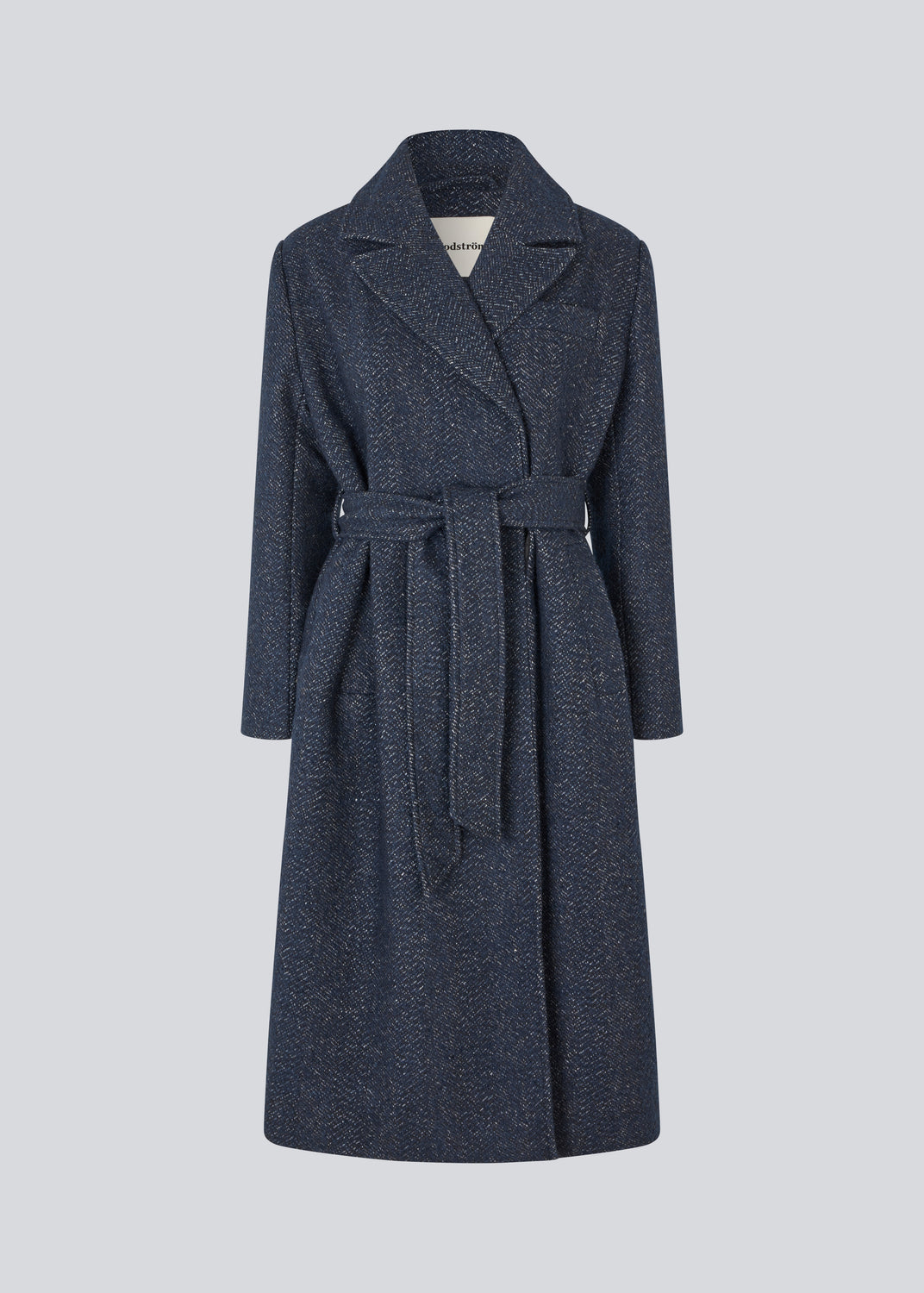 Klassisk, dobbeltradet uldfrakke i blå med krave med skjult knappelukning og bindebånd. Otillamd coat har en afslappet pasform, foer og en slids bagpå. Modellen er 175 cm og har en str. s/36 på.