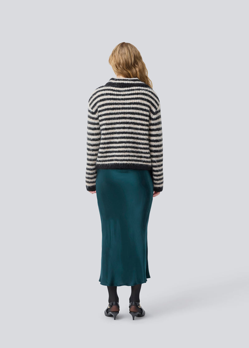 Blød strik med i genanvendt polyester. Packermd roll Neck har lange ærmer og en høj hals med slids i siden. Modellen er 175 cm og har en str. s/36 på.