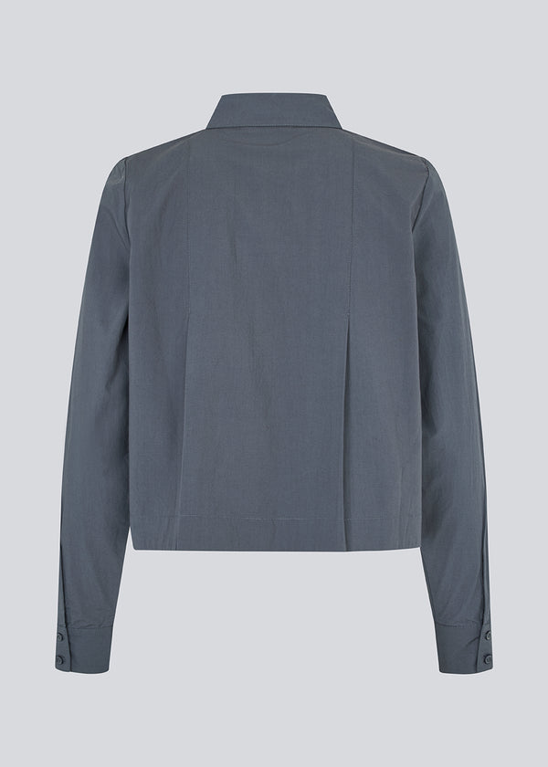 Kort skjorte med læg i 100% økologisk bomuld. Palmermd solid shirt har en skjortekrave og knappelukning fortil.
