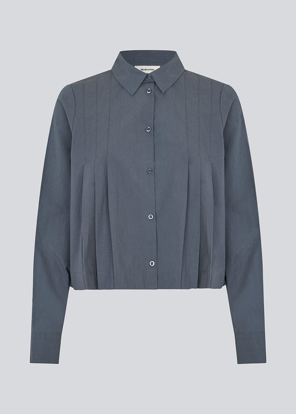 Kort skjorte med læg i 100% økologisk bomuld. Palmermd solid shirt har en skjortekrave og knappelukning fortil.