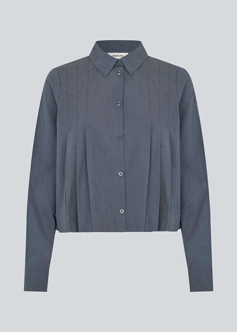 Kort skjorte med læg i 100% økologisk bomuld. Palmermd solid shirt har en skjortekrave og knappelukning fortil.