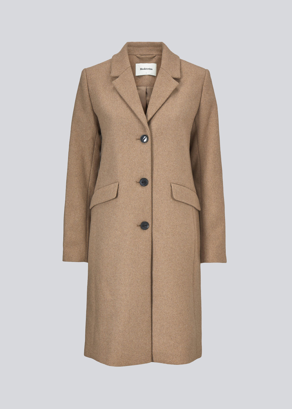 Smuk knælang uldfrakke i beige. Pamela coat i farven Brown Sugar bliver knappet fortil af 3 store knapper og er taljeret, som giver et feminint udtryk. På grund af den høje kvalitet af uld, vil den være det oplagte valg at bruge til både efterår og de milde vintre.