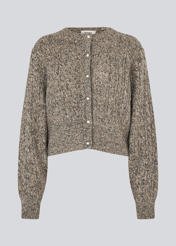 Strikket cardigan i kabelstrik med perleknapper. Pammiemd cardigan har en rund hals og ribkant.