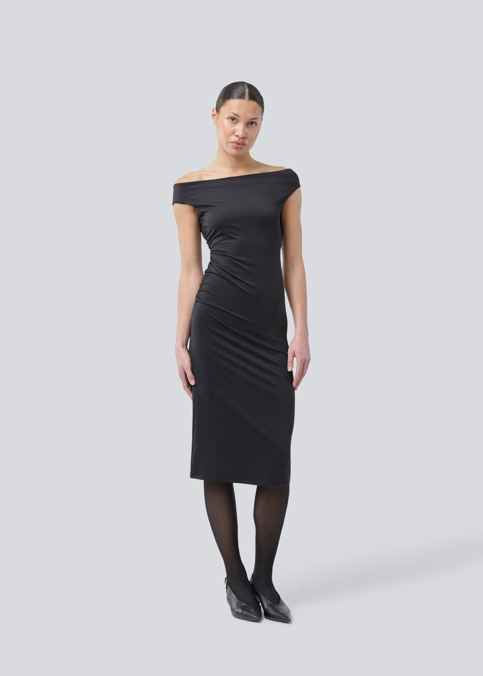 Lang off-shoulder kjole i et elastisk genanvendt materiale. Parissamd dress er figursyet og har rynkedetaljer i siden. Modellen er 175 cm og har en str. S/36 på.