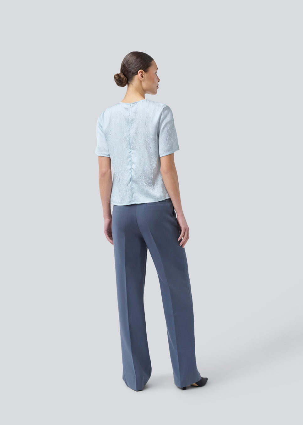 Kortærmet top med rynkedetalje i satin. Parkermd &nbsp;top has en åbning fortil og en usynlig lynlås &nbsp;i ryggen. Modellen er 175 cm og har en str S/36 &nbsp;på.