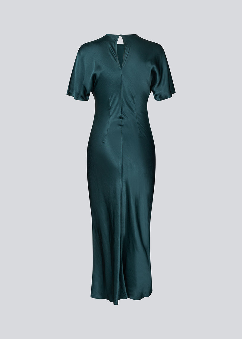 Grøn lang kjole i satin med draperingsdetalje. Parveenmd dress har korte ærmer og en usynlig lynlås i ryggen. Modellen er 175 cm og har en str. s/36 på.