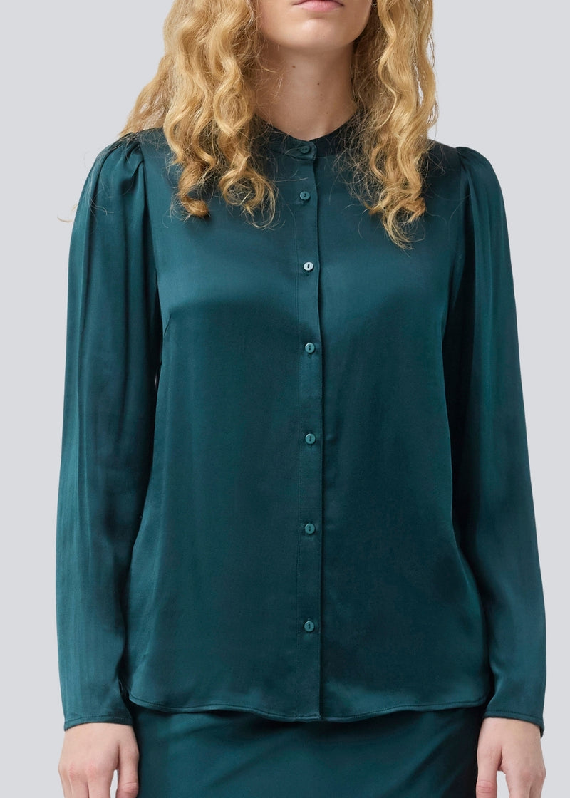 Grøn skjorte med brede ærmer i satin. Parveenmd shirt har en knappelukning fortil. Modellen er 175 cm og har en str. s/36 på.