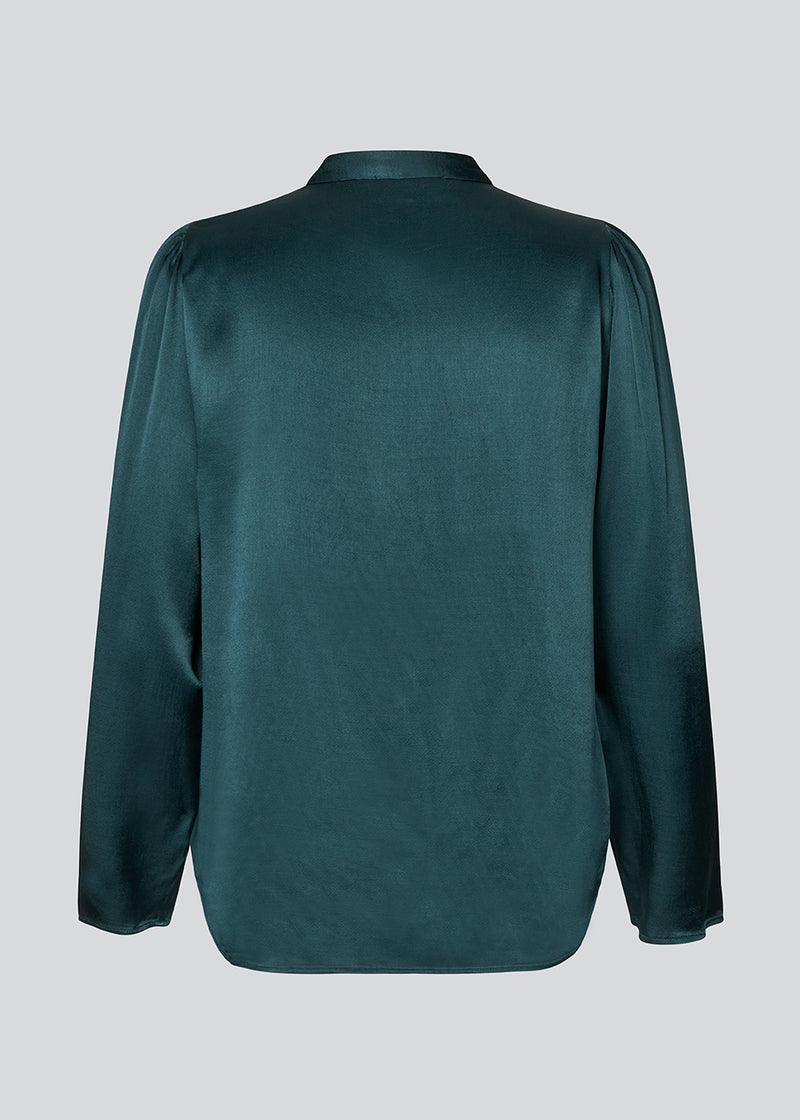 Grøn skjorte med brede ærmer i satin. Parveenmd shirt har en knappelukning fortil. Modellen er 175 cm og har en str. s/36 på.