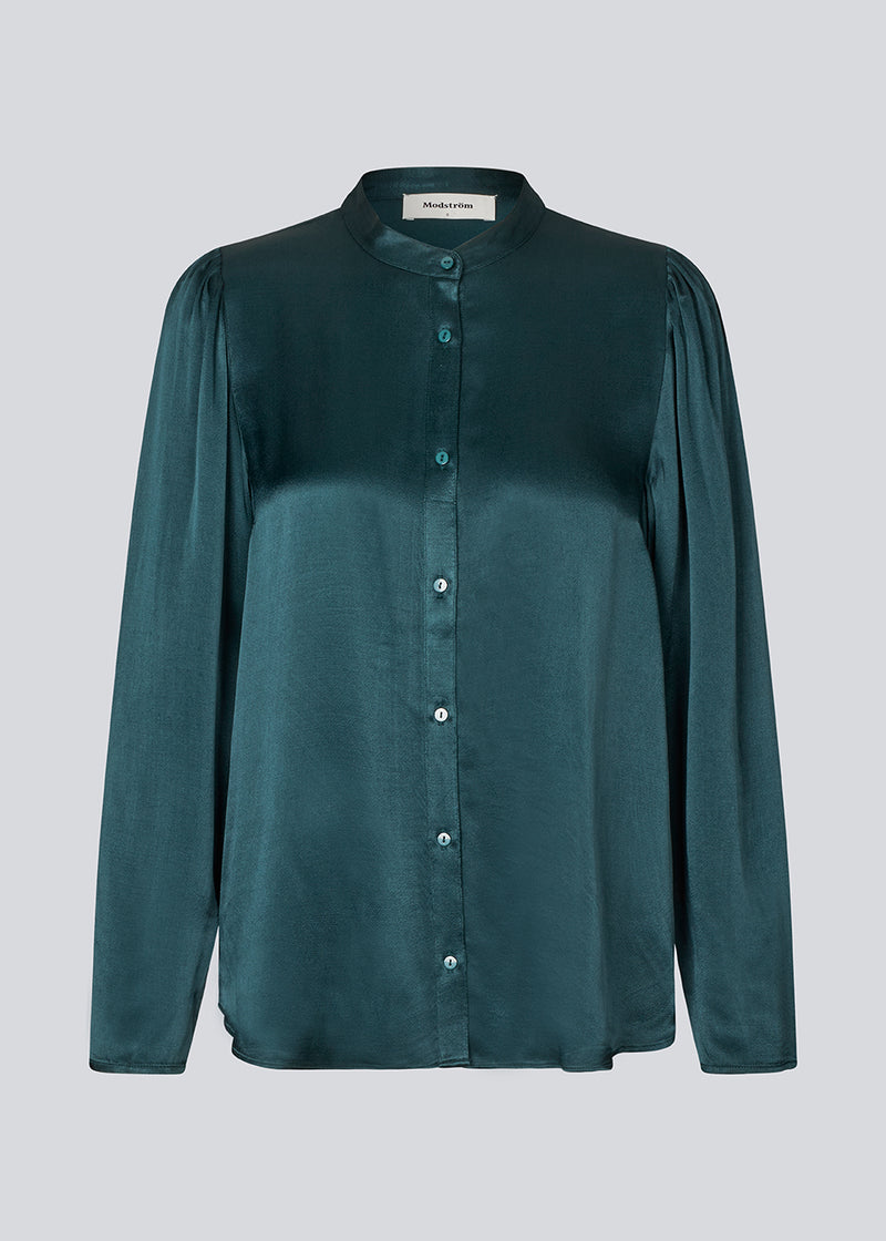 Grøn skjorte med brede ærmer i satin. Parveenmd shirt har en knappelukning fortil. Modellen er 175 cm og har en str. s/36 på.
