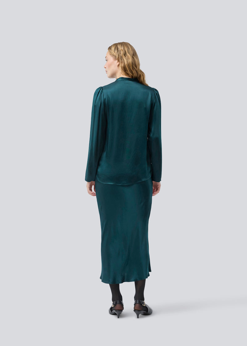 Grøn lang nederdel med vidde i satin. Parveenmd skirt har en elastik i taljen. Modellen er 175 cm og har en str. s/36 på.