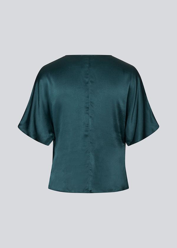 Mørkegrøn top i satin med vandfaldsdetalje. Parveenmd top er figursyet og har korte ærmer.&nbsp;