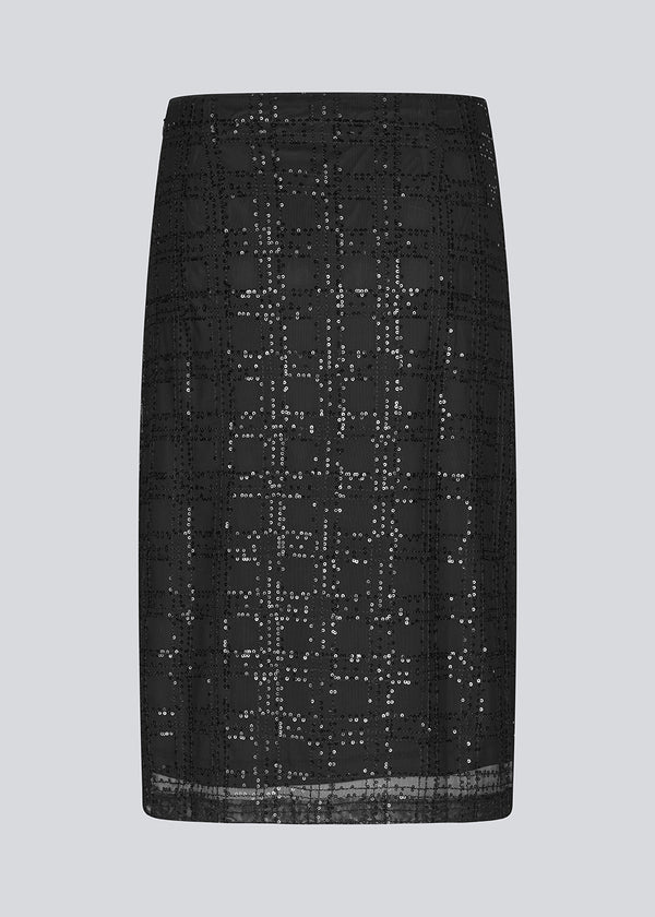 Sort mellemlang nederdel med i et transparant materiale med palietter. Paerleenmd skirt har foer og en usynlig lynlås i siden.
