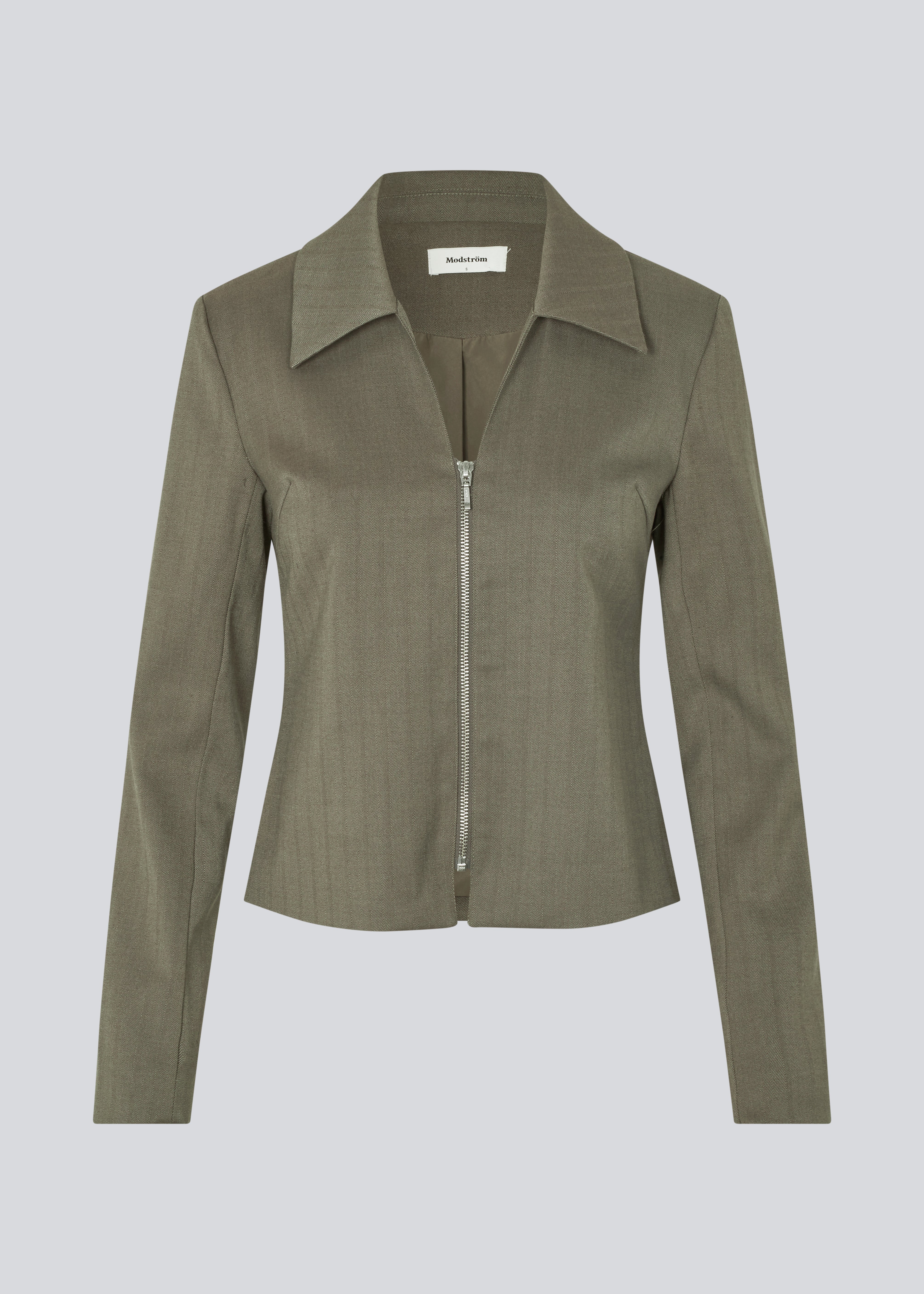 Figursyet blazer med lynlås lukning. Pedromd blazer har lange ærmer, V-udskæring og skjortekrave. Modellen er 175 cm og har en str. S/36 på.