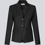 Let figursyet blazer i sort med v-udskæring og knappelukning fortil. Piloumd blazer har to lommer fortil og en slids ved ærmet med knappelukning.&nbsp;