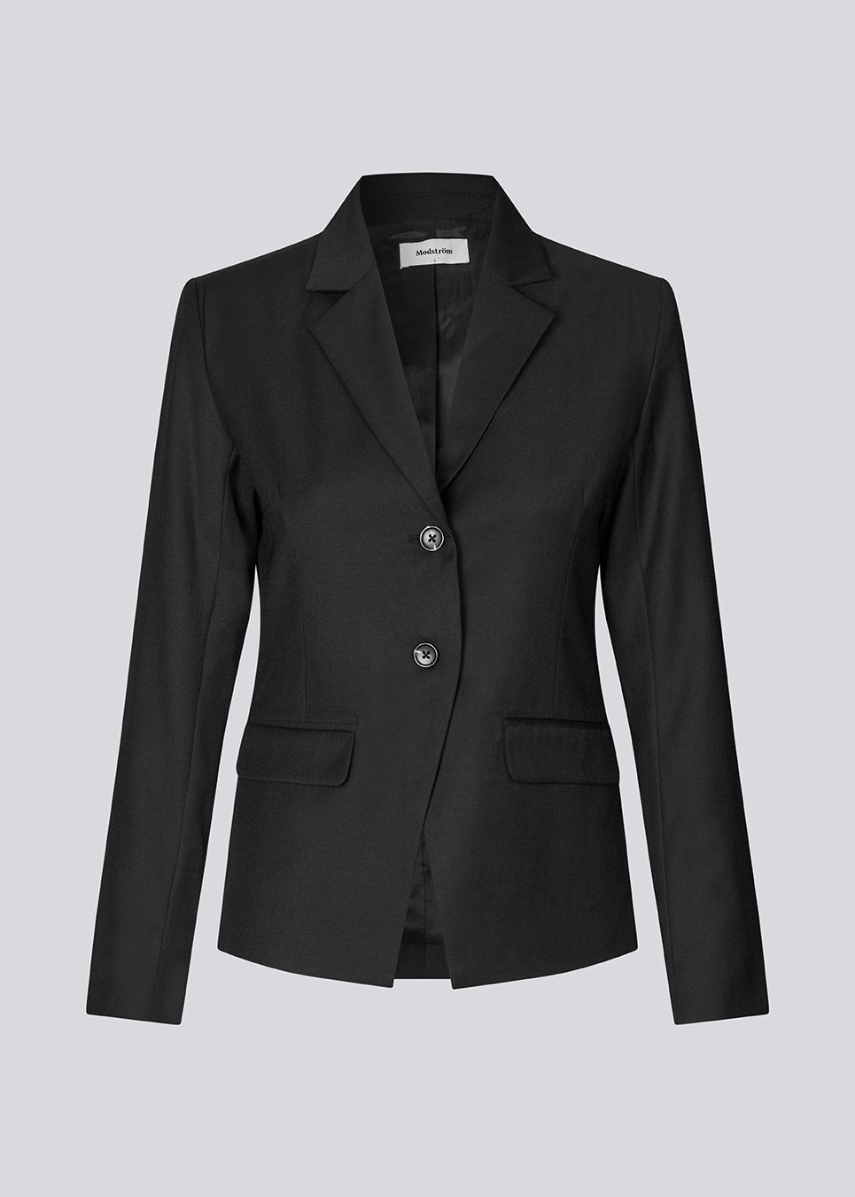 Let figursyet blazer i sort med v-udskæring og knappelukning fortil. Piloumd blazer har to lommer fortil og en slids ved ærmet med knappelukning.&nbsp;