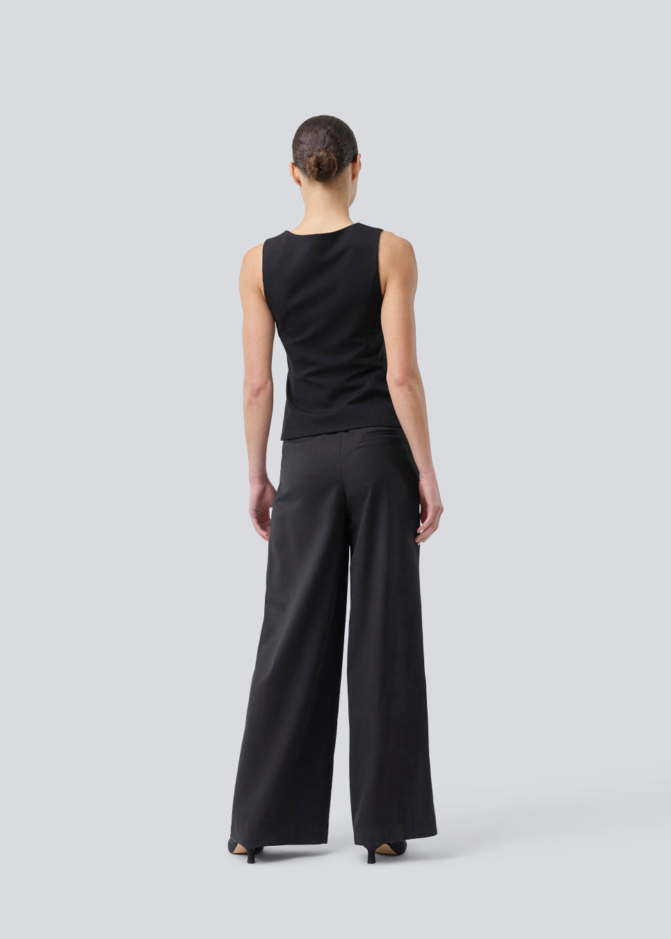 Sorte bukser med brede ben, læg og elastisk talje. Piloumd pants har sidelommer og en lynlås med knappelukning i siden. Modellen er 175 cm og har en str S/36 &nbsp;på.