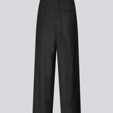 Sorte bukser med brede ben, læg og elastisk talje. Piloumd pants har sidelommer og en lynlås med knappelukning i siden. Modellen er 175 cm og har en str S/36 &nbsp;på.