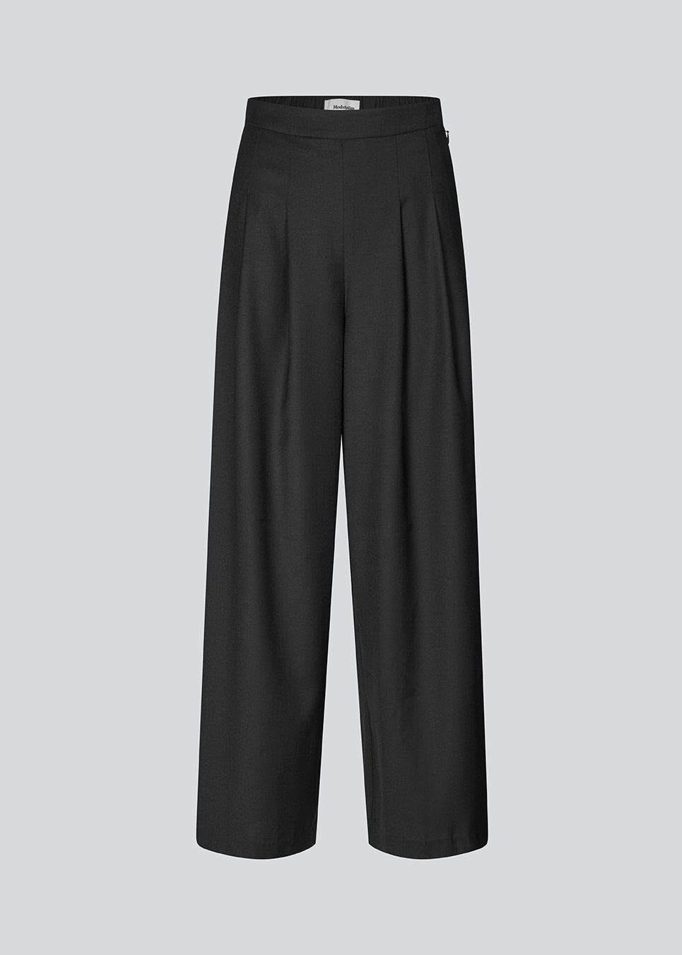 Sorte bukser med brede ben, læg og elastisk talje. Piloumd pants har sidelommer og en lynlås med knappelukning i siden. Modellen er 175 cm og har en str S/36 &nbsp;på.