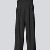 Sorte bukser med brede ben, læg og elastisk talje. Piloumd pants har sidelommer og en lynlås med knappelukning i siden. Modellen er 175 cm og har en str S/36 &nbsp;på.