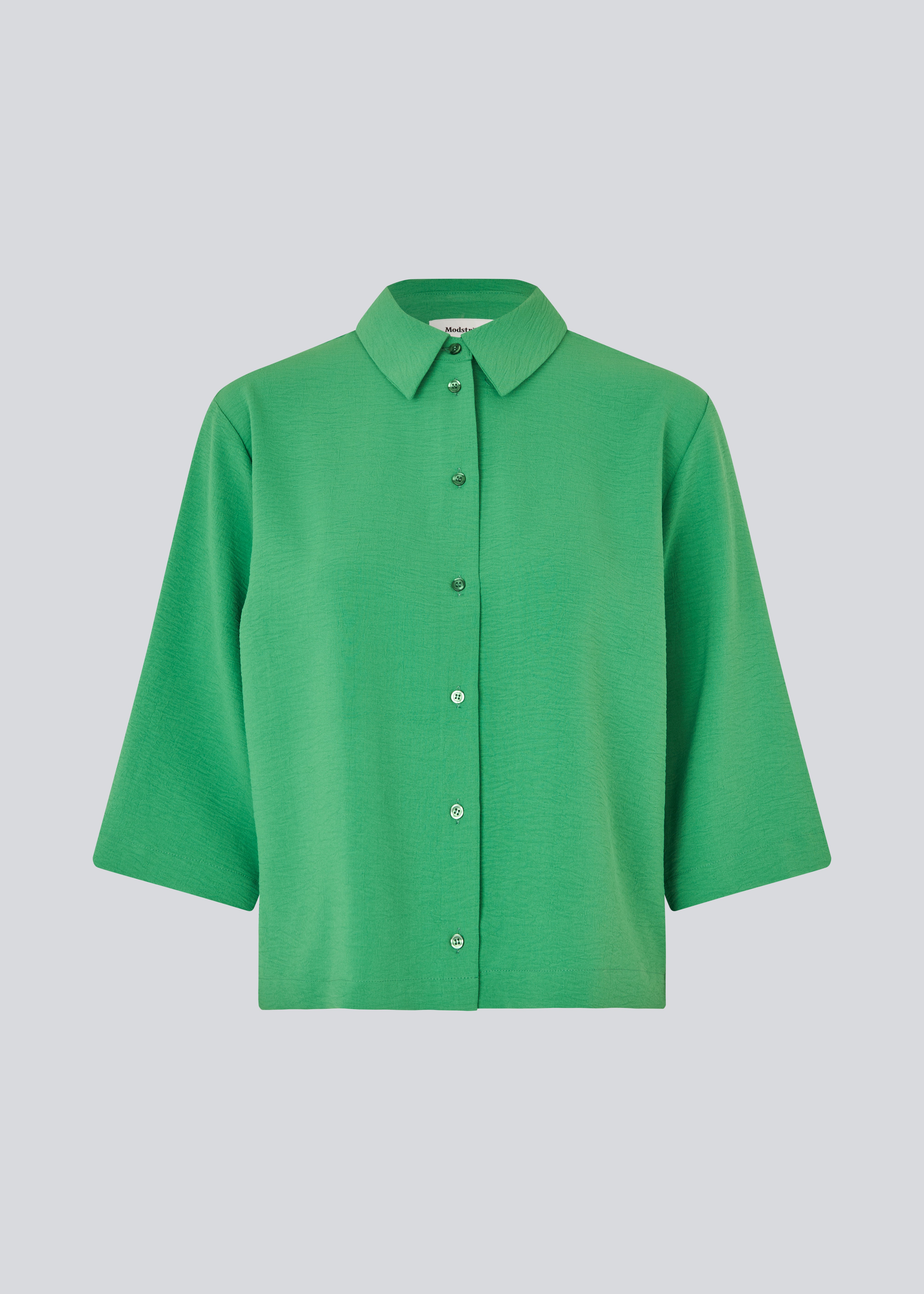 Skjorte med 3/4 ærmer i 100% genanvendt polyester i grøn. Popelmd shirt har en løspasform med knappelukning og skjortekrave.&nbsp;