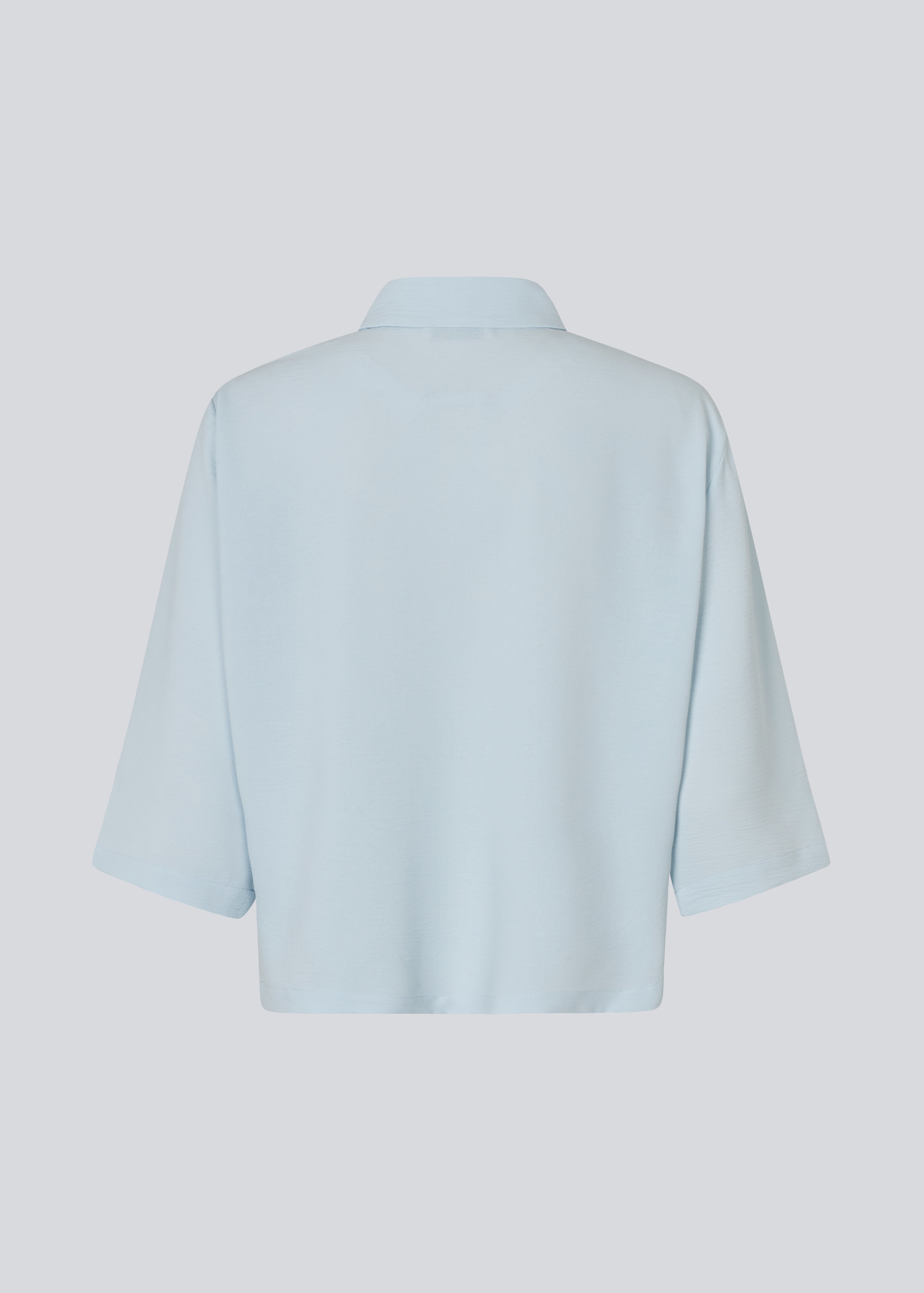Skjorte med 3/4 ærmer i 100% genanvendt polyester i lyseblå. Popelmd shirt har en løspasform med knappelukning og skjortekrave.&nbsp;