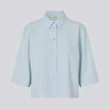 Skjorte med 3/4 ærmer i 100% genanvendt polyester i lyseblå. Popelmd shirt har en løspasform med knappelukning og skjortekrave.&nbsp;