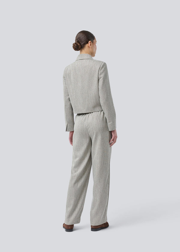 Kort jakke med skjortekrave og knaplukning fortil. Popemd jacket har lange ærmer med slids og en brystlomme. Modellen er 175 cm og har en str. S/36 på.