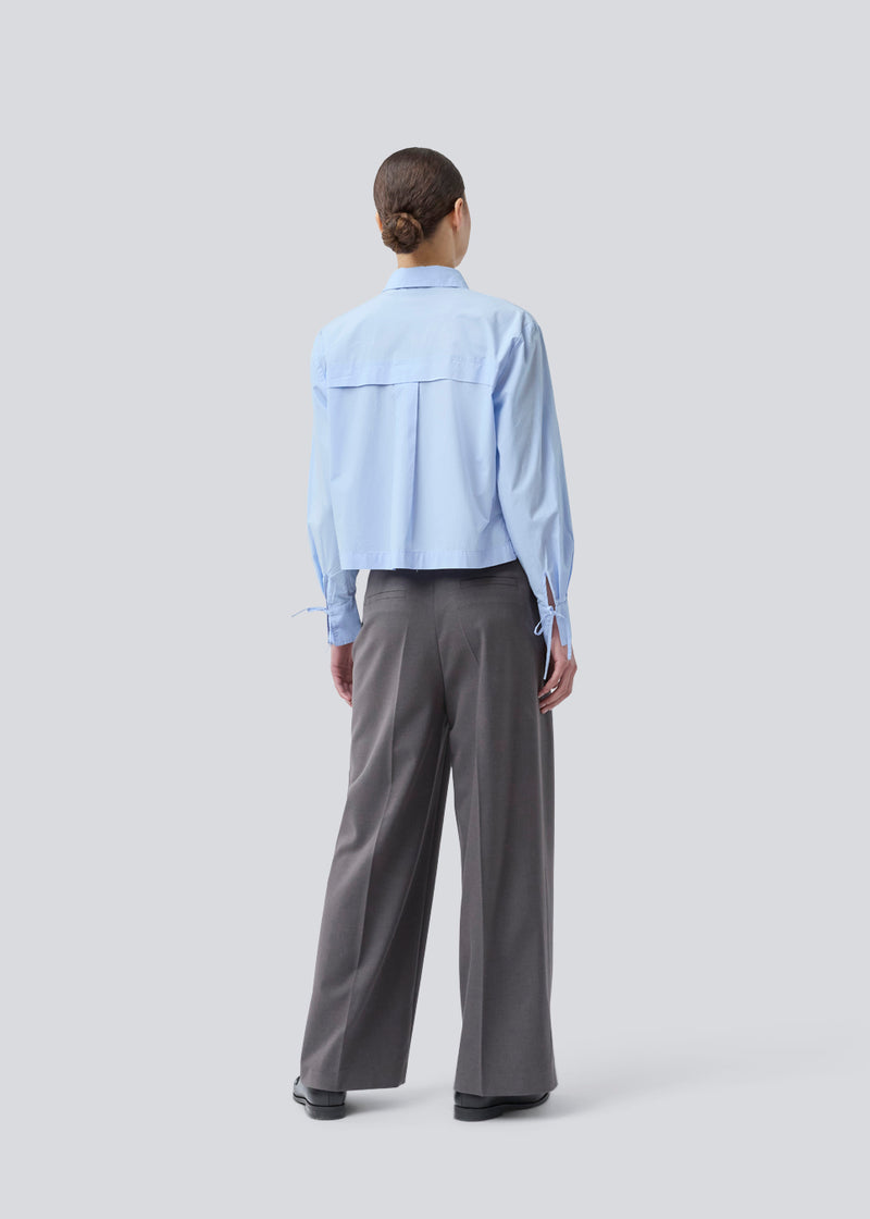 Grå lange habitbukser med brede ben. Primrosemd pants har pressefolder og sidelommer. Modellen er 175 cm og har en str. s/36 på.