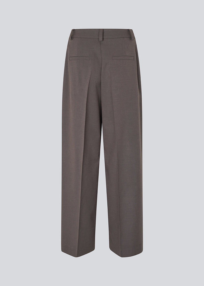 Grå lange habitbukser med brede ben. Primrosemd pants har pressefolder og sidelommer. Modellen er 175 cm og har en str. s/36 på.
