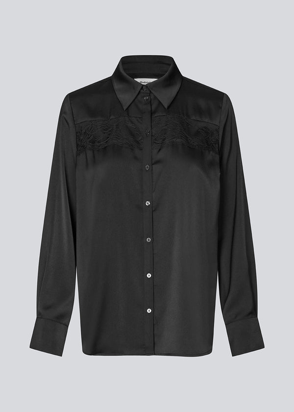 Løs skjorte i satin med blondedetalje på brystet. Prudencemd shirt har en skjortekrave og lange brede ærmer