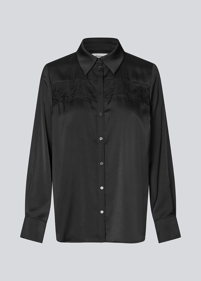 Løs skjorte i satin med blondedetalje på brystet. Prudencemd shirt har en skjortekrave og lange brede ærmer