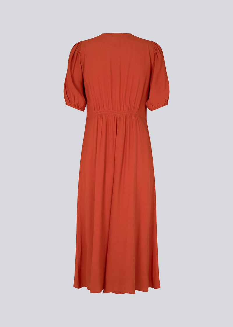 Feminin kjole i rød EcoVero viskose. RavenMD long dress er lang og har flatterende smock detaljer ved skulder og talje. Modellen er 173 cm og har en størrelse S/36 på