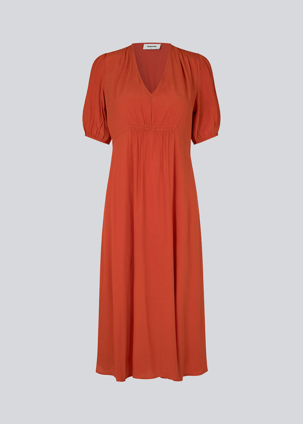 Feminin kjole i rød EcoVero viskose. RavenMD long dress er lang og har flatterende smock detaljer ved skulder og talje. Modellen er 173 cm og har en størrelse S/36 på
