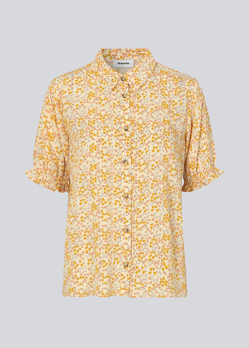 Blomstret skjorte i farven Bobble Bloom Peach med korte, puffede ærmer med elastik. RavenMD print shirt har normal krave og knapper foran. Pasformen er afslappet. Modellen er 173 cm og har en størrelse S/36 på
