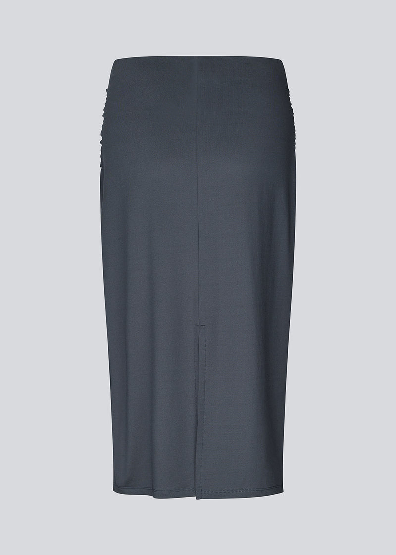 Midi nederdel i genanvendt polyester. Richardmd skirt er en tætsiddende nederdel med en smuk draperingsdetajle og guld spænde fortil – enkel og feminin.