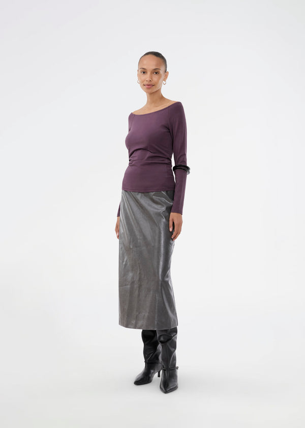 Nederdel i skinnede imiteret læder. Ridgemd skirt har en høj talje og en slids bag på - perfekt til både et råt og feminint look.
