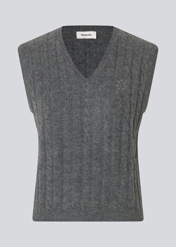 Tætsiddende vest i kabelstrik. Risemd vest er tidsløs og har et broderet logo på brystet. Perfekt til et cool og klassisk lag-på-lag look.