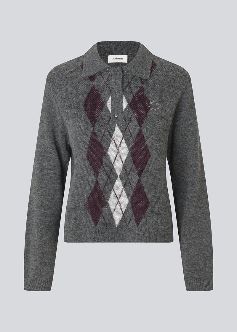 Polo inspireret strik med lange ærmer. Roganmd polo strik har harlekinmønster og et broderet logo på brystet, der giver stikken en klassisk udtyk.