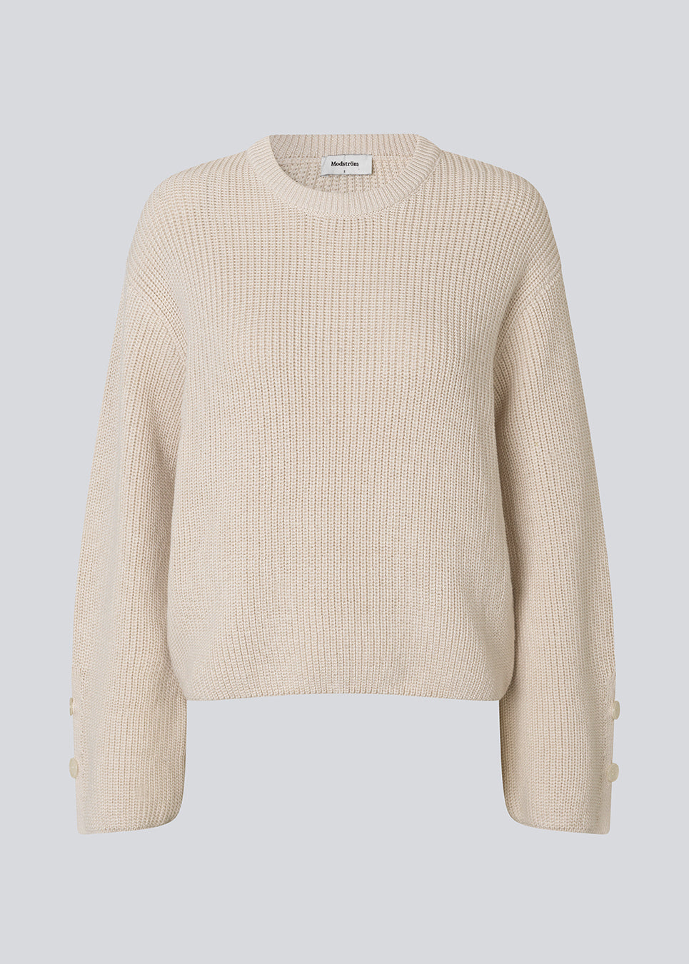 Striktrøje i hvud/creme i økologisk bomuld. Rosemd o-neck har rund hals og knapdetaljer på ærmerne – en enkel og klassisk style.