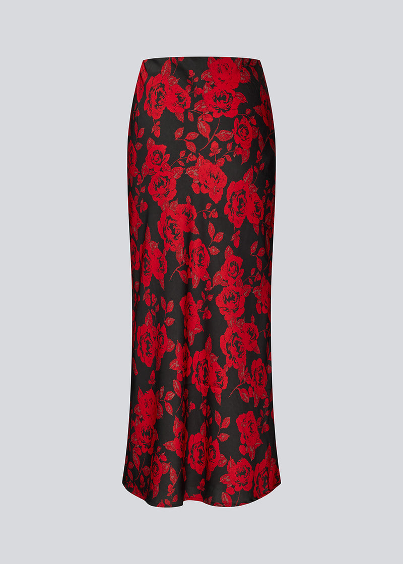 Lang nederdel i et smukt rosenprint. Ruthiemd skirt har elastik i taljen og er lavet i genanvendt polyester– &nbsp;en klassisk og elegant style.