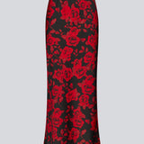 Lang nederdel i et smukt rosenprint. Ruthiemd skirt har elastik i taljen og er lavet i genanvendt polyester– &nbsp;en klassisk og elegant style.