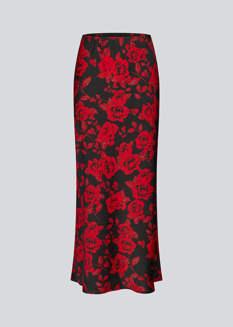 Lang nederdel i et smukt rosenprint. Ruthiemd skirt har elastik i taljen og er lavet i genanvendt polyester– &nbsp;en klassisk og elegant style.